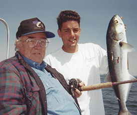 Captain Steve and his grandfather, Bob, in younger years with Bob holding a reel and Steve holding a fish.