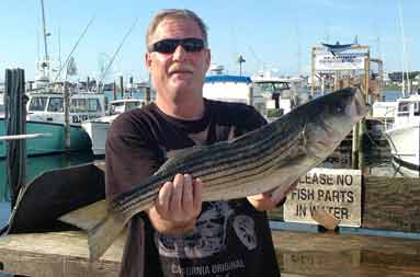 Bob back at the marina, holding up the large bass he caught.