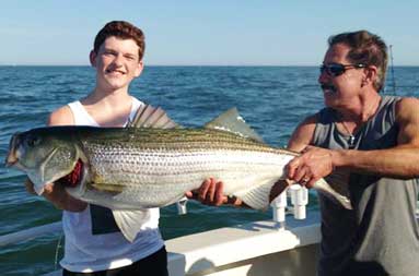 Capt. Mike Danon helps hold up another 35 pounder.
