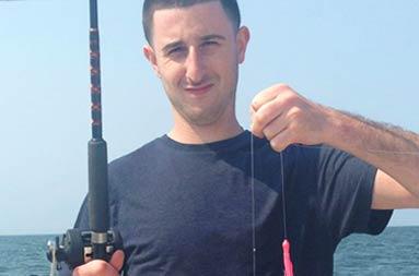 One of the guys holding up a sea bass that he caught