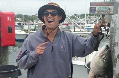 One of the guys smiles holding another 30 pound bass