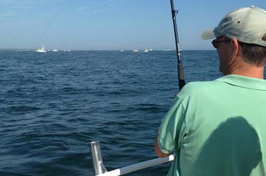 Rear shot of anotherone of the guys reeling in a fish