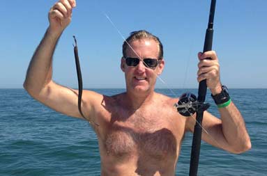One of the guys, Marshall, holding an eel on the line