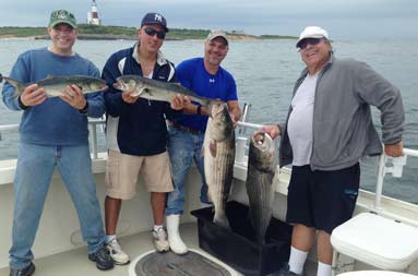 The guys standing on the boat, each holding up their catch