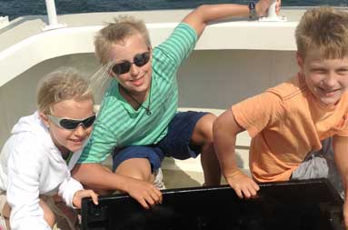 The barrel full of scup with the kids posing next to it