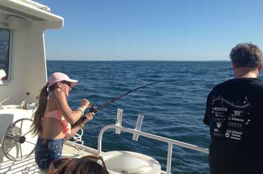 One of the adult women reeling in a fish