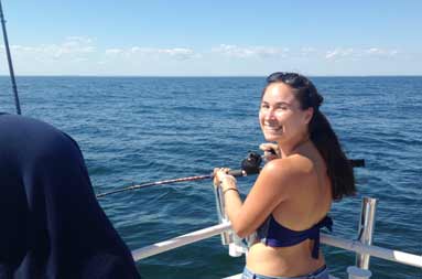 Another one of the adult women reeling in a fish