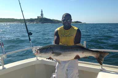 Metrit on the boat holding the bass he caught