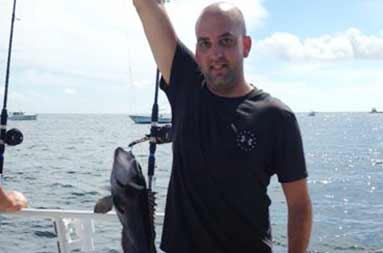 One of the guys holding up his line with 2 fish caught on it