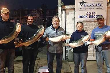 Night group shot of everyone holding up their catch