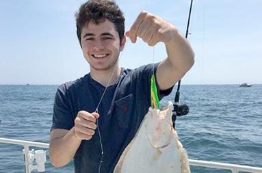 One of the guys, Ben, holding up a fluke he caught.