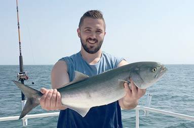 One of the guys holding up a bluefish