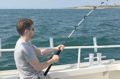 One of the guys sitting with his reel in the water waiting for a bite.