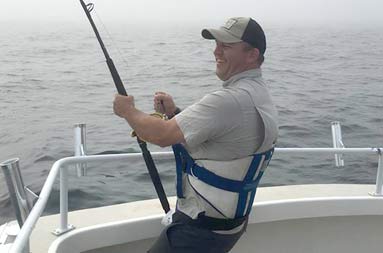 One of the guys wearing a harness reeling in a shark.