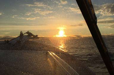 The vast dark ocean on bottom with the top half of the horizon glowing from the rising sun.