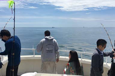 View from the cabin of everyone on deck with two lines in the water and Capt. Steve checking things out/.