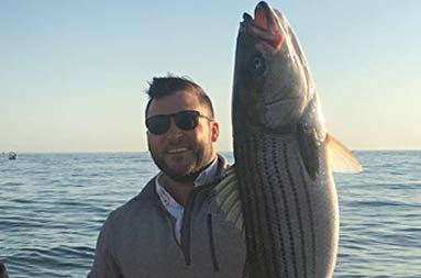A man holding up the fish he caught.