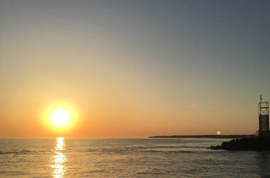 View from the boat of the sunrise over the ocean.