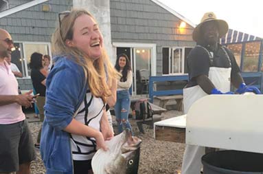 Back at the marina, an adolescent girl laughs as she attempts to lift the 45lb fish she caught.